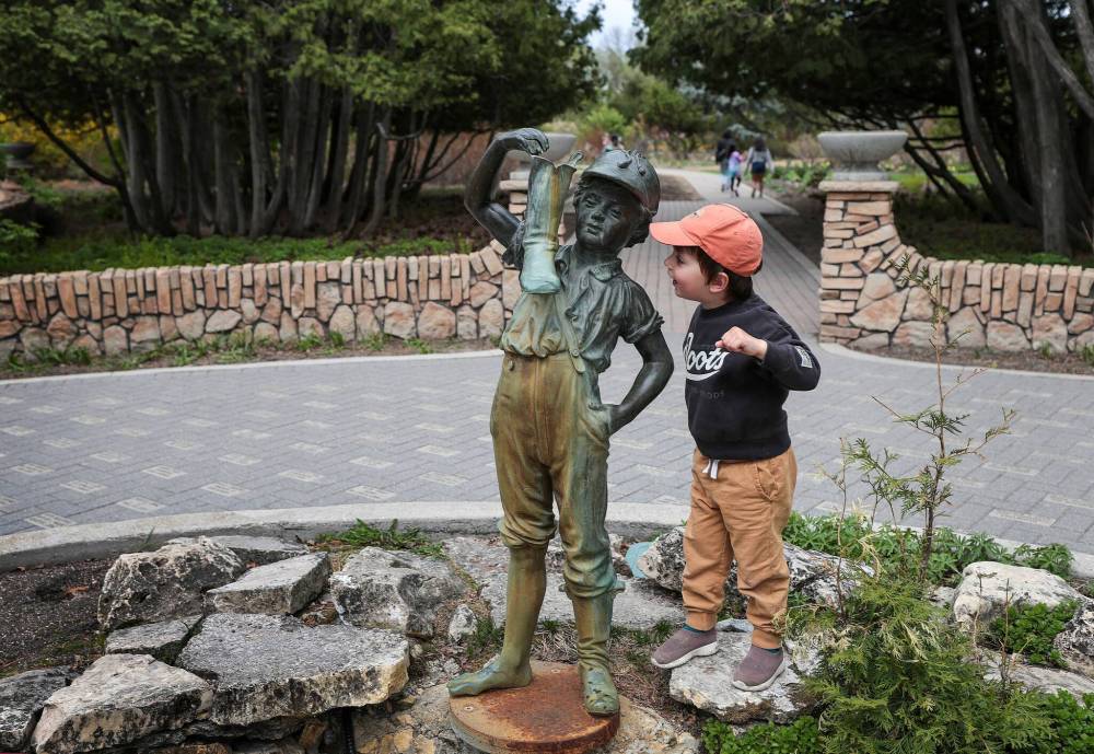 Ruth Bonneville / Free Press
Jackson Grusko, age three, gets a closer look at the Boy with the Boot statue at the entrance to the Assiniboine Park’s English Garden Monday. The statue is one of several structures that are being considered for heritage status.