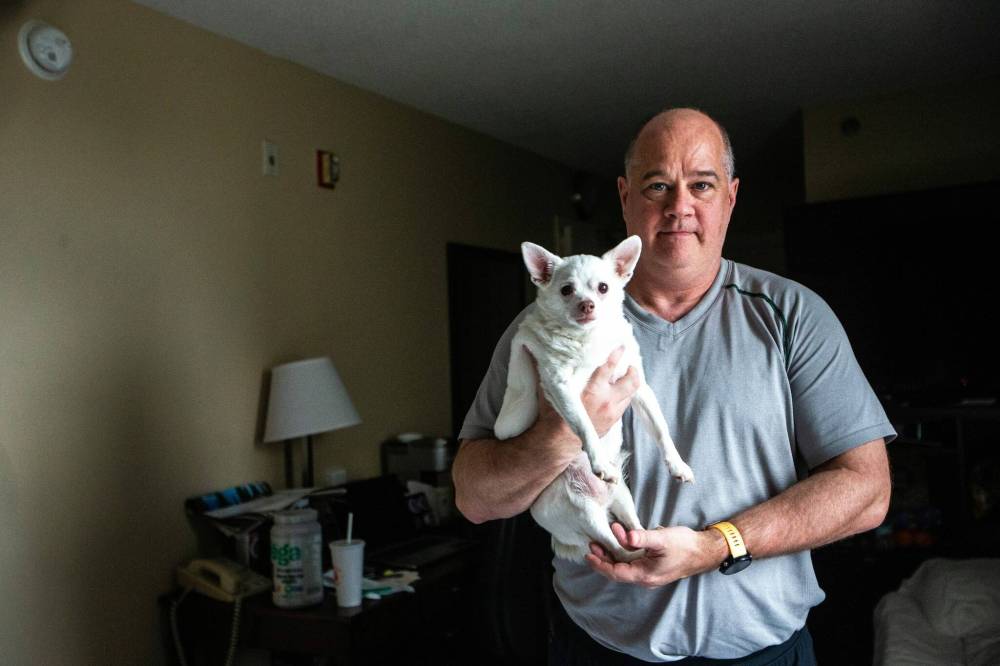 MIKAELA MACKENZIE / FREE PRESS
Des Kappel, a displaced resident from Birchwood Terrace, with his dog Nemo in the hotel room they are currently staying in.
