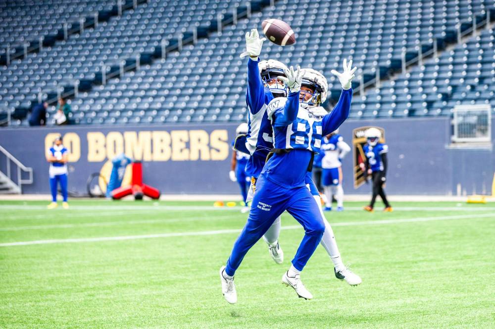 MIKAELA MACKENZIE / FREE PRESS
Ontaria Wilson (front) and Nico McCarthy compete for a catch Wendesday at Blue Bombers training camp.