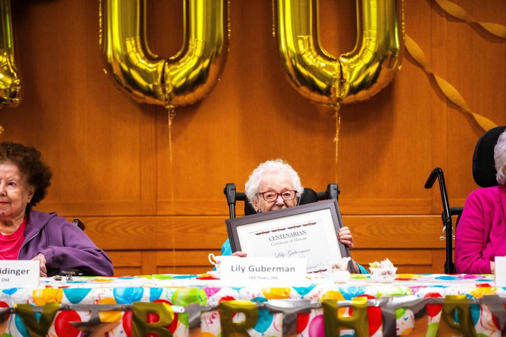 MIKAELA MACKENZIE / FREE PRESS
Simkin Centre resident Lily Guberman (102) holds up her certificate during a birthday celebration, Thursday.