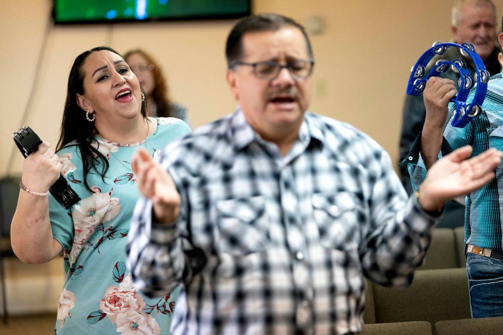 Guadalupe Rodriguez Pino, left, sings with members of her church’s congregation as as they worship during a church service, Sunday, Dec. 17, 2023, in Fort Morgan, Colo. Rodriguez and her husband, who have four U.S.-born children, are in the process of getting legal immigration status. (AP Photo/Julio Cortez)