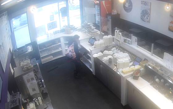 Security footage shows a woman stealing cash from the Cinnaholic branch on McPhillips Street, near Kingsbury Avenue. (Supplied)
