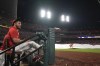 St. Louis Cardinals' Willson Contreras sits in the dugout as a member of the Busch Stadium grounds crew rushes to unfurl the tarp at the start of a rain delay during the sixth inning of a baseball game between the Cardinals and the Baltimore Orioles Tuesday, May 21, 2024, in St. Louis. (AP Photo/Jeff Roberson)