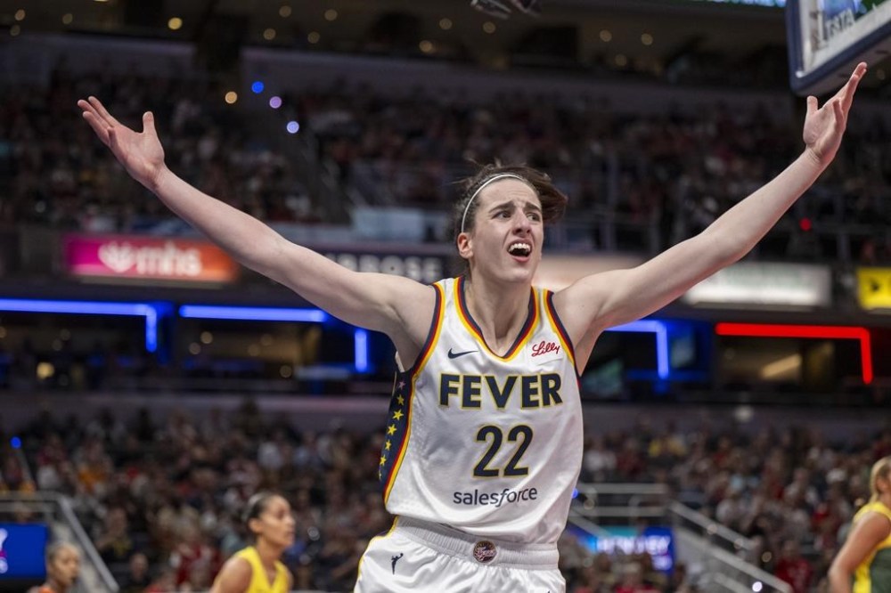 FILE - Indiana Fever guard Caitlin Clark reacts after scoring against the Seattle Storm during the first half of a WNBA basketball game Thursday, May 30, 2024, in Indianapolis. (AP Photo/Doug McSchooler, File)