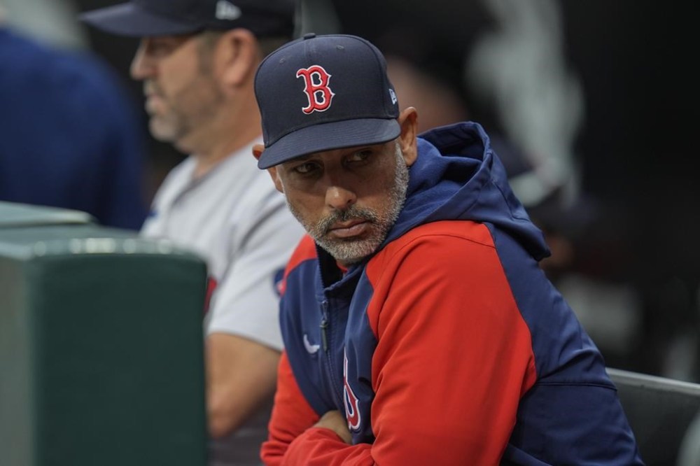 Boston Red Sox manager Alex Cora sits in the dugout during the first inning of a baseball game against the Chicago White Sox, Saturday, June 8, 2024, in Chicago. (AP Photo/Erin Hooley)