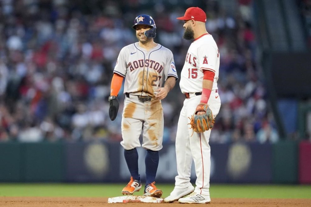 Houston Astros' Jose Altuve, left, speaks with Los Angeles Angels second baseman Luis Guillorme, right, after stealing second during the third inning of a baseball game, Saturday, June 8, 2024, in Anaheim, Calif. (AP Photo/Ryan Sun)