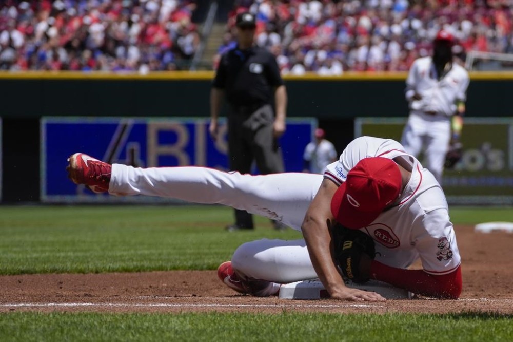 Cincinnati Reds first baseman Jeimer Candelario falls onto the base after catching a line drive by Chicago Cubs' Pete Crow-Armstrong during the first inning of a baseball game, Sunday, June 9, 2024, in Cincinnati. (AP Photo/Joshua A. Bickel)