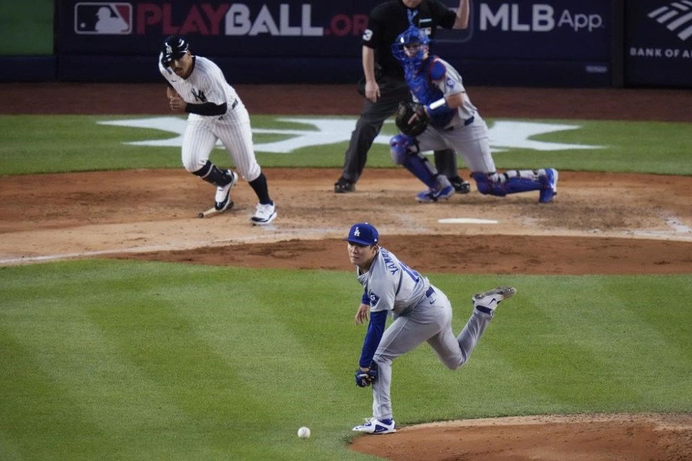 Los Angeles Dodgers pitcher Yoshinobu Yamamoto reaches for a ball hit by New York Yankees' Trent Grisham during the fifth inning of a baseball game, Friday, June 7, 2024, in New York. Grisham was out on the play. The Dodgers won 2-1 in 11 innings. (AP Photo/Frank Franklin II)