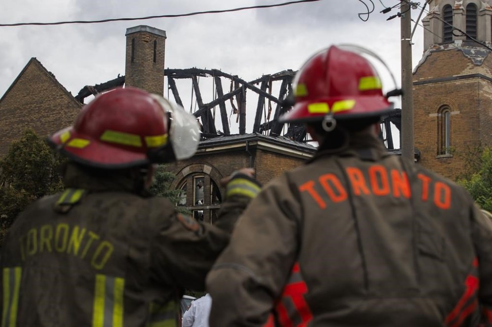 Firefighters work to put out a blaze at St. Anne's Anglican Church in Toronto's west end on Sunday, June 9, 2024. THE CANADIAN PRESS/Cole Burston