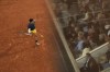 Spectators are reflected in glass as Spain's Carlos Alcaraz plays a shot against Greece's Stefanos Tsitsipas during their quarterfinal match of the French Open tennis tournament at the Roland Garros stadium in Paris, Tuesday, June 4, 2024. (AP Photo/Christophe Ena)