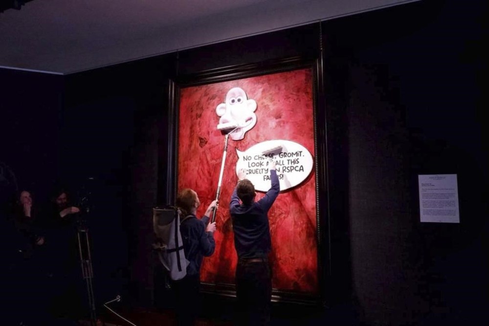 This photo released by Animal Rising shows activists pasting a picture of a character called Wallace, from the “Wallace and Gromit” comedy series, over a portrait of Britain's King Charles III at the Philip Mould Gallery in London, Tuesday June 11, 2024. Animal rights activists pasted a cartoon image over a portrait of King Charles III on Tuesday at a London art gallery, the latest in a series of incidents at U.K. museums as campaigners use vandalism to publicize their causes. (Animal Rising via AP)