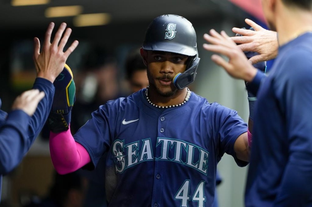 Seattle Mariners' Julio Rodríguez is greeted in the dugout after scoring against the Chicago White Sox during the third inning of a baseball game Tuesday, June 11, 2024, in Seattle. (AP Photo/Lindsey Wasson)