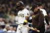 San Diego Padres' Jurickson Profar, left, is escorted off the field by a trainer during an at-bat against the Oakland Athletics in the eighth inning of a baseball game Tuesday, June 11, 2024, in San Diego. (AP Photo/Derrick Tuskan)