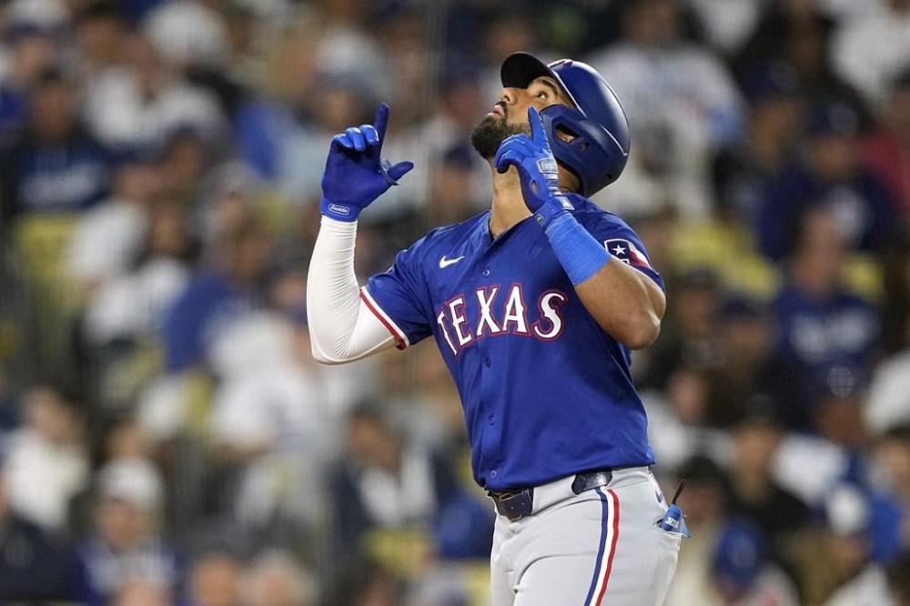 Texas Rangers' Ezequiel Duran gestures as he scores after hitting a solo home run during the seventh inning of a baseball game against the Los Angeles Dodgers Tuesday, June 11, 2024, in Los Angeles. (AP Photo/Mark J. Terrill)