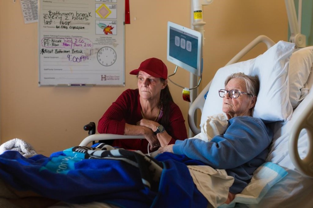 Michele Campeau, left, visits with her mother, Ruth Poupard, 83, at Hotel-Dieu Grace Healthcare where she is recovering from a broken hip, in Windsor, Ont., on April 3, 2024. More than 400 patients have been forced into Ontario nursing homes they did not want to go to and the rate of those moves is increasing, The Canadian Press has learned. THE CANADIAN PRESS/Dax Melmer