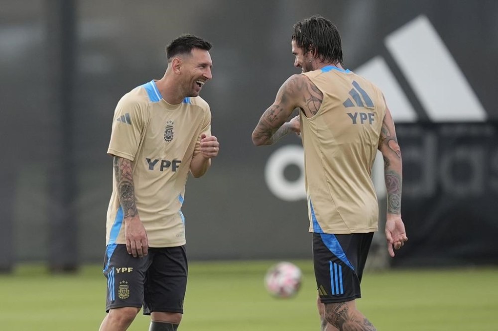 Lionel Messi, left, laughs with Rodrigo De Paul as members of Argentina's soccer team train ahead of the Copa America soccer tournament, Wednesday, June 5, 2024, in Fort Lauderdale, Fla. The 16-nation tournament will be played in 14 U.S. cities starting with Argentina's opener in Atlanta on June 20, 2024. (AP Photo/Rebecca Blackwell)