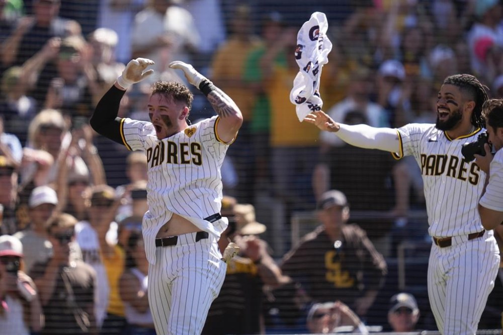 San Diego Padres' Jackson Merrill, left, celebrates with teammate Fernando Tatis Jr. after his game-winning solo home run against the Oakland Athletics during the ninth inning of a baseball game Wednesday, June 12, 2024, in San Diego. The Padres won, 5-4. (AP Photo/Gregory Bull)