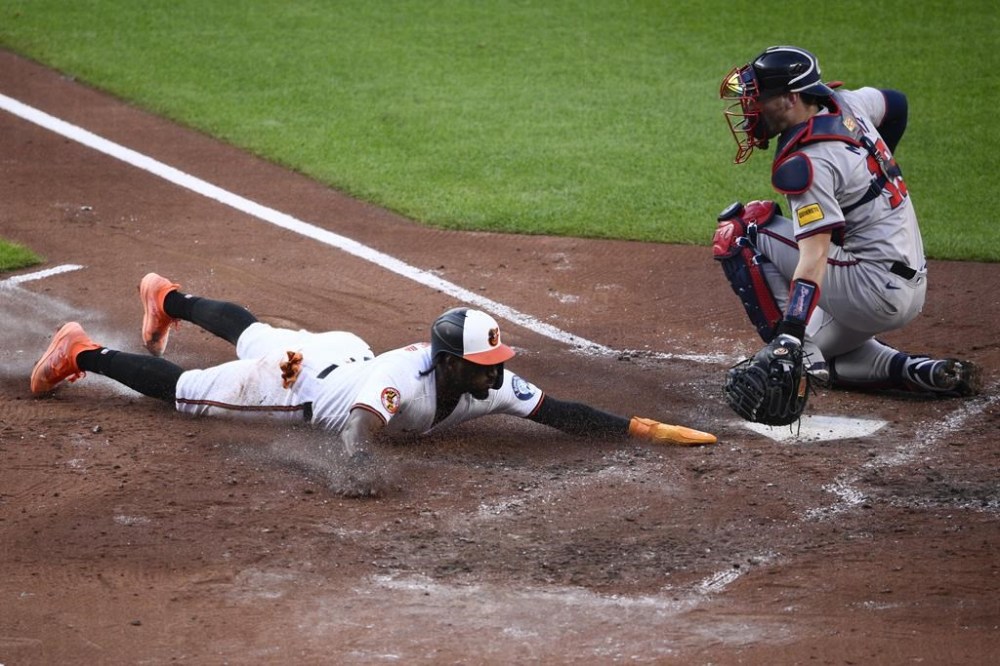 Baltimore Orioles' Jorge Mateo slides home to score Atlanta Braves catcher Sean Murphy, right, during the third inning of a baseball game, Wednesday, June 12, 2024, in Baltimore. (AP Photo/Nick Wass)