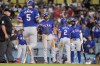 Texas Rangers designated hitter Corey Seager (5) scores on a three-run home run against the Los Angeles Dodgers as Leody Taveras, Marcus Semien and Adolis Garcia, from left, wait to congratulate him during the fifth inning of a baseball game Wednesday, June 12, 2024, in Los Angeles. (AP Photo/Ryan Sun)