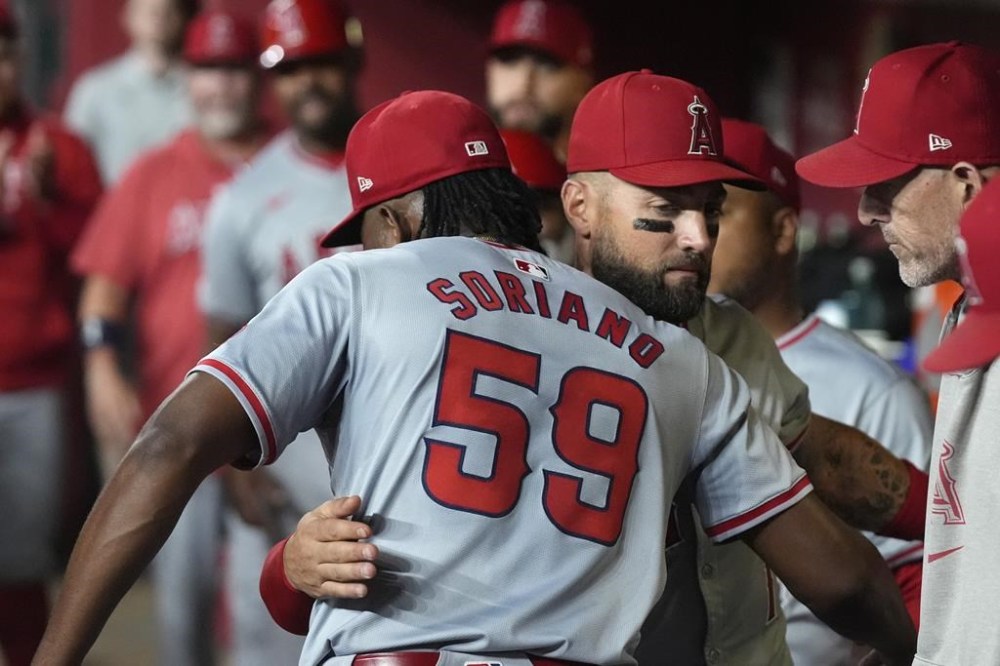 Los Angeles Angels starting pitcher José Soriano (59) gets a hug from Kevin Pillar after Soriano pitched into the ninth inning of the team's baseball game against the Arizona Diamondbacks, Wednesday, June 12, 2024, in Phoenix. The Angels won 8-3. (AP Photo/Ross D. Franklin)