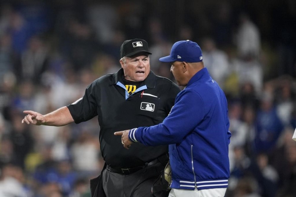 Los Angeles Dodgers manager Dave Roberts gestures at umpire Marvin Hudson to review a play during the ninth inning of the team's baseball game against the Texas Rangers on Wednesday, June 12, 2024, in Los Angeles. (AP Photo/Ryan Sun)