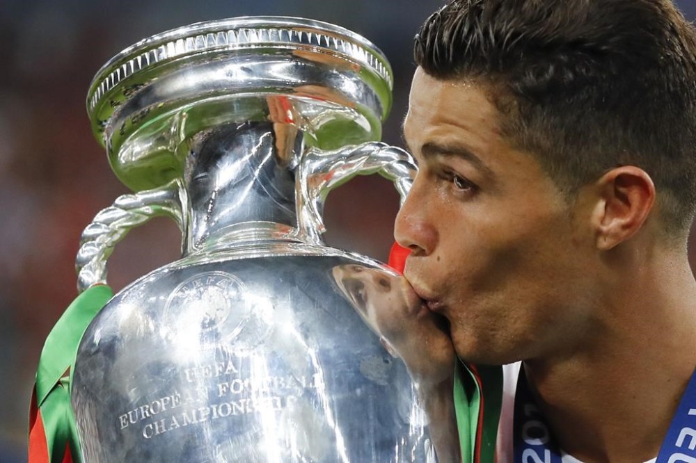FILE - In this Sunday, July 10, 2016 file photo, Portugal's Cristiano Ronaldo kisses the trophy at the end of the Euro 2016 final soccer match between Portugal and France at the Stade de France in Saint-Denis, north of Paris. The Euros kick off in Munich, Friday June 14, when host country Germany plays Scotland at Bayern Munich's Allianz Arena. The tournament begins with six groups of four teams. (AP Photo/Frank Augstein, File)