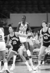 FILE - Washington Bullets center Manute Bol towers over opponents and teammates during the team's NBA basketball game against the San Antonio Spurs in New York, Oct. 17, 1985. Just 13 years after South Sudan emerged from civil war to become an independent nation in 2011, it will mark a milestone next month when the world’s youngest nation makes its Olympic basketball debut. Bol introduced Luol Deng to basketball. (AP Photo/G. Paul Burnett, File)