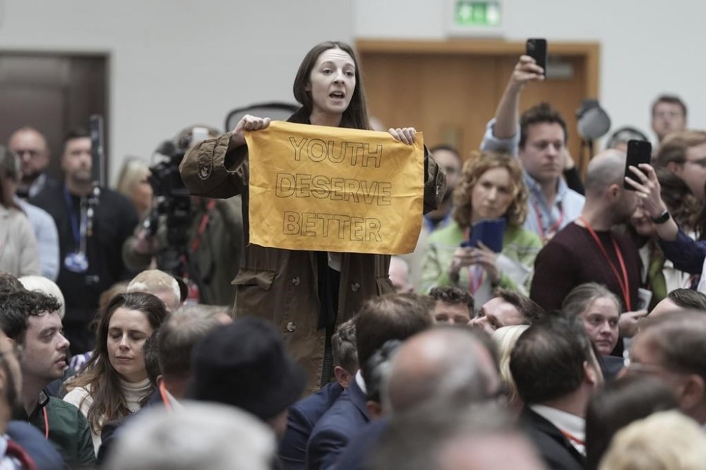 A person stands and speaks out in the audience before being ejected, as Labour Party leader Sir Keir Starmer launches his party's manifesto in Manchester, England, Thursday June 13, 2024. (Stefan Rousseau/PA via AP)