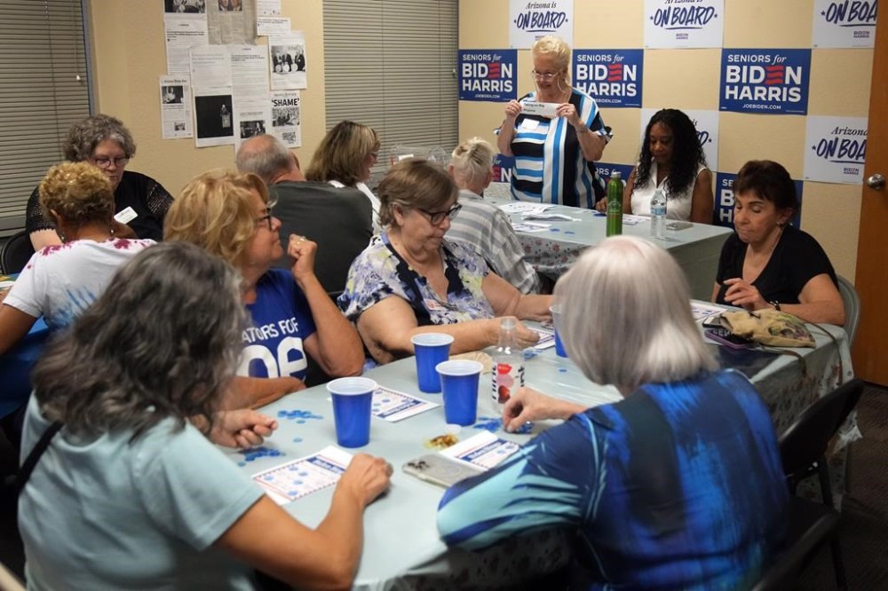 DeAnna Mireau, top, calls out the subjects during a game of bingo at a campaign event for seniors in support of President Joe Biden's reelection campaign, Thursday, June 13, 2024, in Phoenix. (AP Photo/Rick Scuteri)