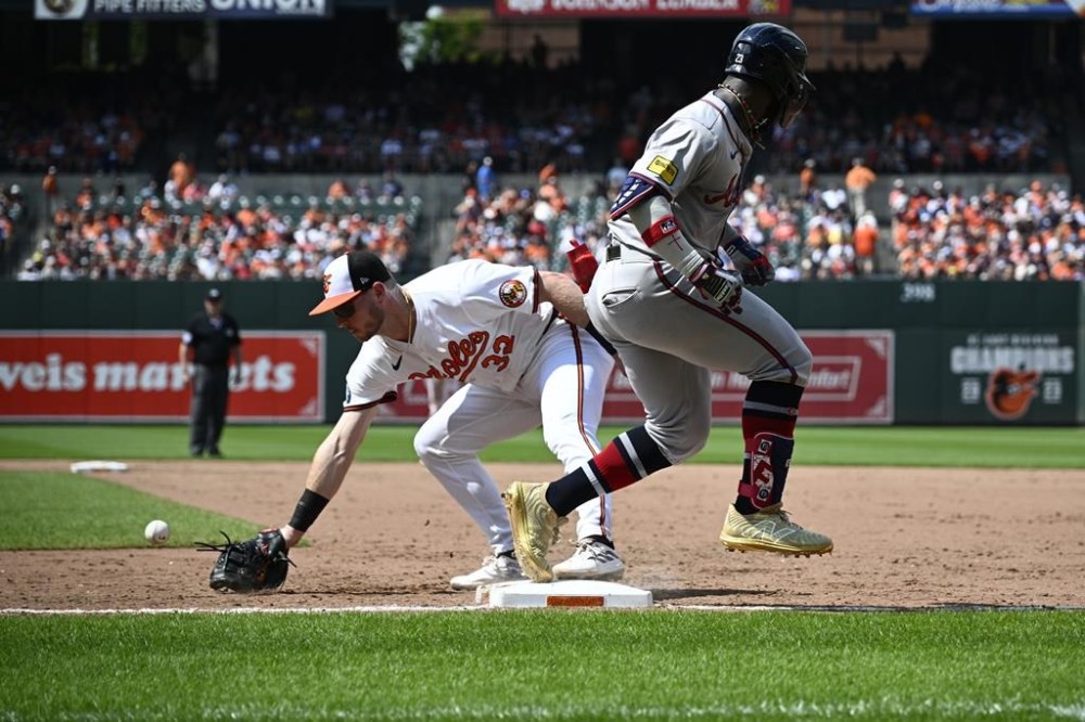 Atlanta Braves' Michael Harris II, right, reaches first base on an error Baltimore Orioles first baseman Ryan O'Hearn (32) during the ninth inning of a baseball game, Thursday, June 13, 2024, in Baltimore. The Braves won 6-3. (AP Photo/Nick Wass)