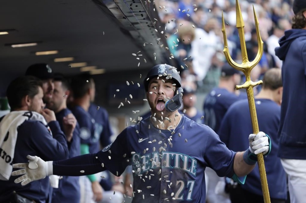 Seattle Mariners' Tyler Locklear celebrates in the dugout after hitting a solo home run on a pitch from Chicago White Sox pitcher Garrett Crochet during the fifth inning of a baseball game, Thursday, June 13, 2024, in Seattle. (AP Photo/John Froschauer)