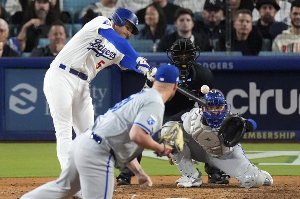 Los Angeles Dodgers' Freddie Freeman, left, hits an RBI single as Kansas City Royals relief pitcher Will Smith, second from left, watches along with catcher Freddy Fermin, right, and home plate umpire Gabe Morales during the eighth inning of a baseball game Friday, June 14, 2024, in Los Angeles. (AP Photo/Mark J. Terrill)