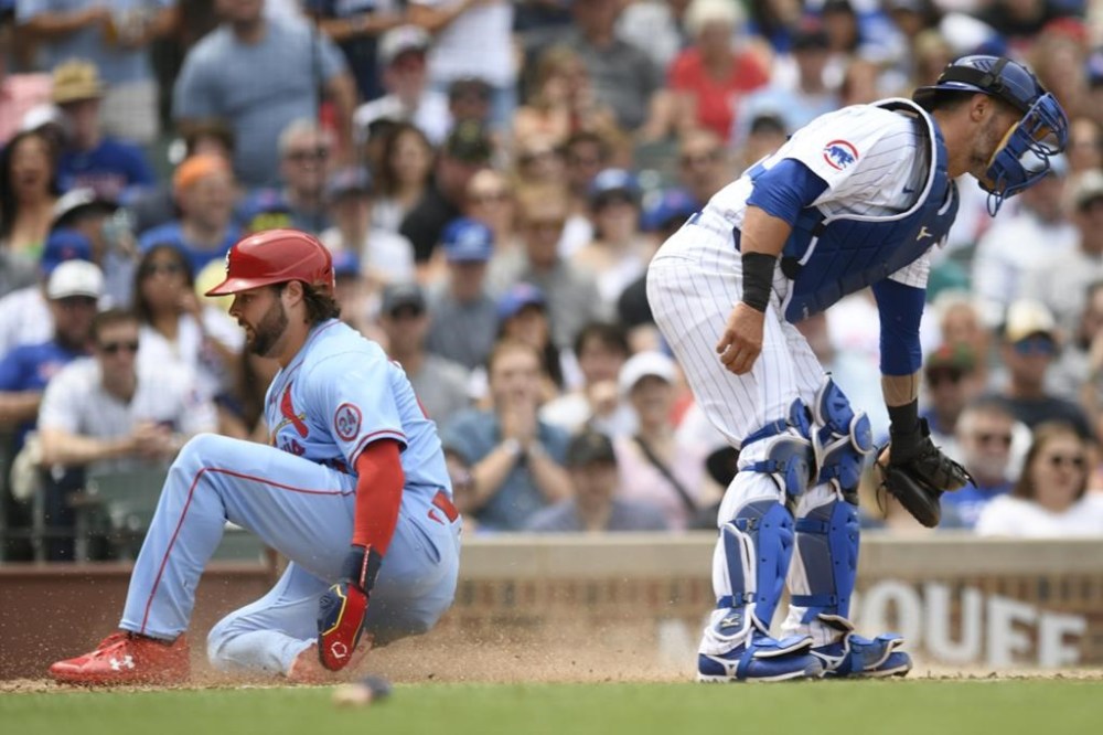 St. Louis Cardinals' Alec Burleson left, scores on a Nolan Arenado's sacrifice fly as Chicago Cubs catcher Yan Gomes right, waits for the throw during the fourth inning of a baseball game Saturday, June 15, 2024, in Chicago. (AP Photo/Paul Beaty)