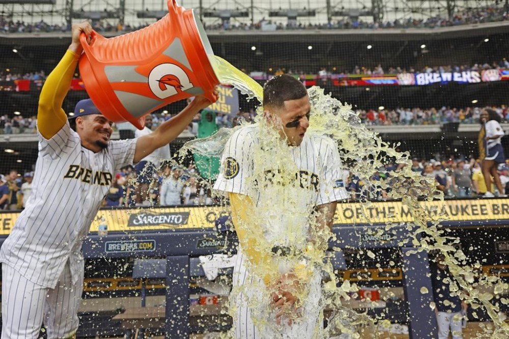 Milwaukee Brewers' Willy Adames, left, douses Joey Ortiz after the team's baseball game against the Cincinnati Reds on Saturday, June 15, 2024, in Milwaukee. (AP Photo/Jeffrey Phelps)