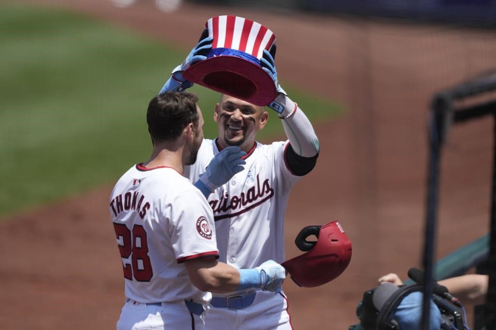 Washington Nationals outfielder Lane Thomas (28) is congratulated by teammate Ildemaro Vargas, right, after hitting a home run during the first inning of a baseball game against the Miami Marlins, Sunday, June 16, 2024, in Washington. (AP Photo/Susan Walsh)