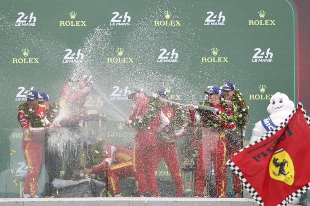 Ferrari 499P Hybrid Hypercar WEC's team, Spanish driver Miguel Molina, Italian driver Antonio Fuoco, and Danish driver Nicklas Nielsen and other team members celebrate on the podium after winning Le 24 Hours of Le Mans sports-car race Sunday, June 16, 2024, in Le Mans, France. (AP Photo/Jeremias Gonzalez)