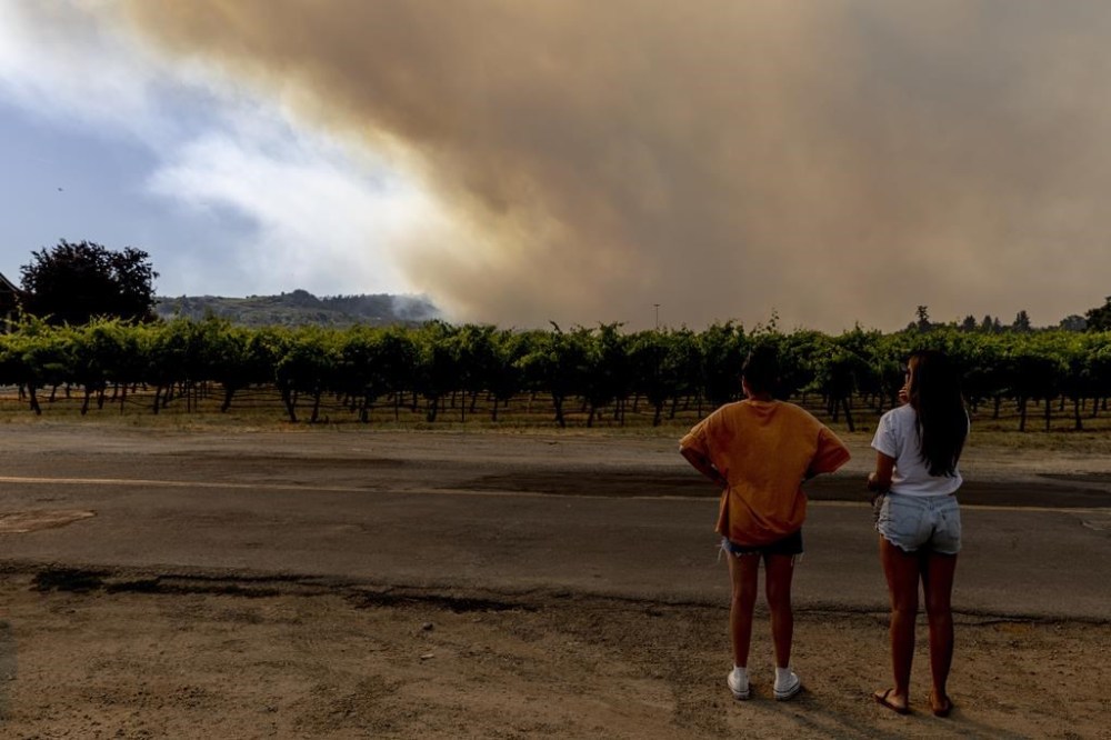 Motorists stop to watch a smoke column during the Point Fire in Healdsburg, Calif., Sunday, June 16, 2024. (Stephen Lam/San Francisco Chronicle via AP)