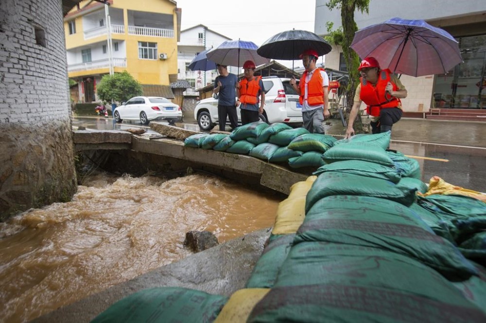In this photo released by Xinhua News Agency, workers inspect flood prevention measures at a drainage channel in Hongxing Village of Xingcun Township of Wuyishan, Nanping City, southeast China's Fujian Province, June 16, 2024. Southern China was reeling Tuesday from heavy rains that triggered landslides killing at least nine people, knocking out power for entire villages and burying crops. Meanwhile, northern parts of the country are battling drought, as the country faces two extremes of severe weather.( (Chen Ying/Xinhua via AP)