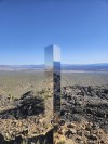 This photo provided by Las Vegas Metropolitan Police Department shows a monolith near Gass Peak, Nev., on Sunday, June 16, 2024. Jutting out of the rocks on a remote mountain peak near Las Vegas, the glimmering rectangular prism's reflective surface imitates the vast desert landscape surrounding the mountain peak where it has been erected. (Las Vegas Metropolitan Police Department via AP)