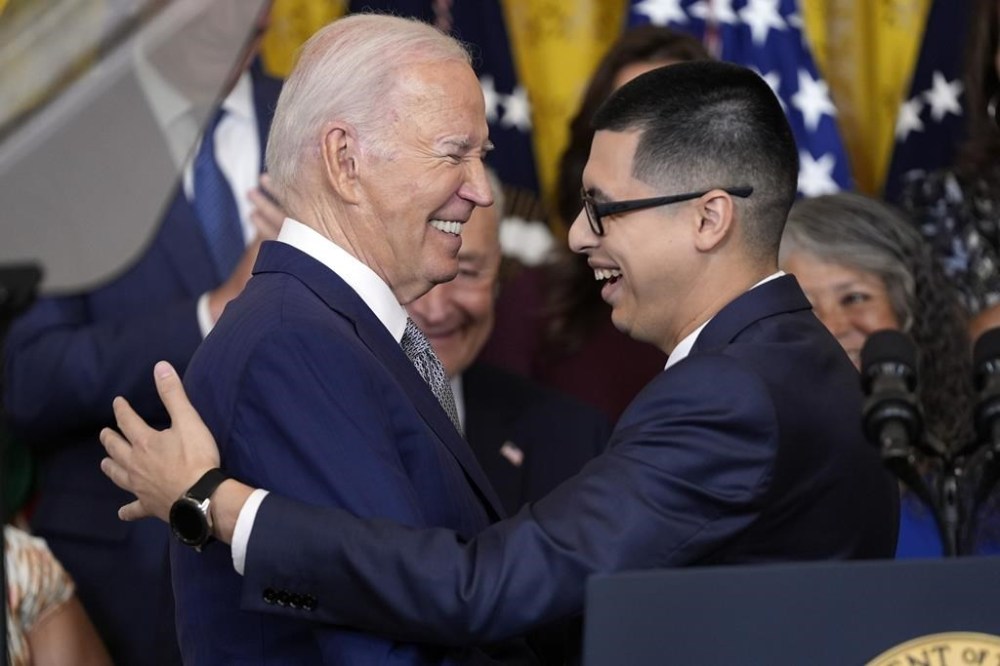 Javier Quiroz Castro gives a hug to President Joe Biden after introducing him at an event marking the 12th anniversary of the Deferred Action of Childhood Arrivals program, in the East Room of the White House, Tuesday, June 18, 2024, in Washington. (AP Photo/Evan Vucci)