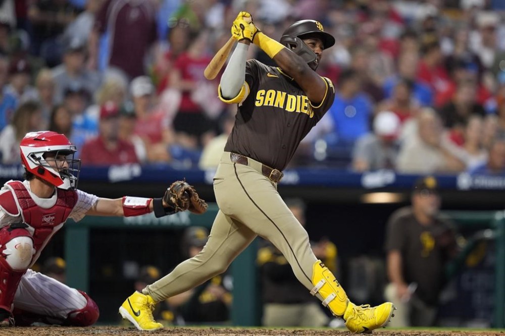 San Diego Padres' Jurickson Profar follows through after hitting a run-scoring single against Philadelphia Phillies pitcher Aaron Nola during the sixth inning of a baseball game, Tuesday, June 18, 2024, in Philadelphia. (AP Photo/Matt Slocum)