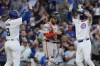 Chicago Cubs' Dansby Swanson, right, celebrates with Ian Happ, left, after hitting a two-run home run, while San Francisco Giants catcher Curt Casali, center, looks at his glove during the second inning of a baseball game in Chicago, Tuesday, June 18, 2024. (AP Photo/Nam Y. Huh)