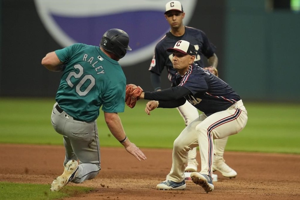 Cleveland Guardians second baseman Andres Gimenez, right, tags out Seattle Mariners' Luke Raley (20) at second base in the seventh inning of a baseball game Tuesday, June 18, 2024, in Cleveland. (AP Photo/Sue Ogrocki)