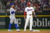 New York Mets shortstop Francisco Lindor, left, talks with Texas Rangers' Marcus Semien during the third inning of a baseball game, Tuesday, June 18, 2024, in Arlington, Texas. (AP Photo/Julio Cortez)
