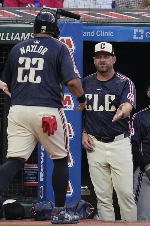 Cleveland Guardians manager Stephen Vogt, right, greets Josh Naylor (22), who returns to the dugout after scoring against the Seattle Mariners during the sixth inning of a baseball game Tuesday, June 18, 2024, in Cleveland. (AP Photo/Sue Ogrocki)