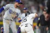 Los Angeles Dodgers shortstop Miguel Rojas, left, tags out Colorado Rockies' Hunter Goodman in a rundown between first and second base in the seventh inning of a baseball game Tuesday, June 18, 2024, in Denver. (AP Photo/David Zalubowski)