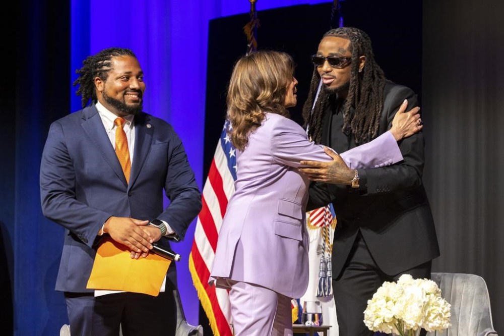 Vice President Kamala Harris, center, hugs hip-hop star Quavo at his summit to stop gun violence at the Carter Center in Atlanta on Tuesday, June 18, 2024, as Deputy Director of the White House Office of Gun Violence Prevention Greg Jackson, left, looks on. (Arvin Temkar/Atlanta Journal-Constitution via AP)