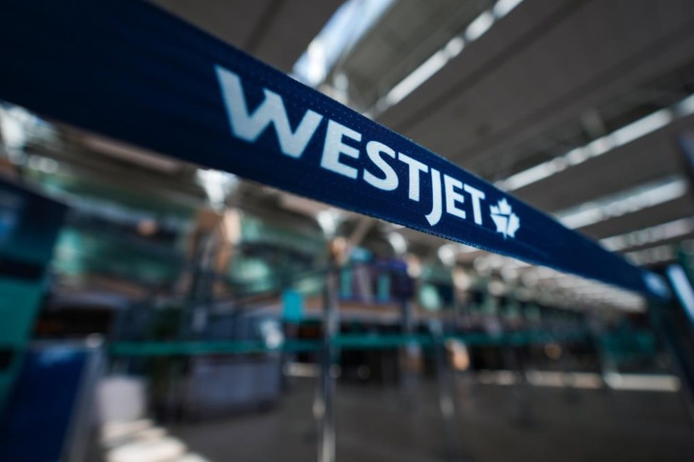 A WestJet logo is seen in the domestic check-in area at Vancouver International Airport, in Richmond, B.C., on Friday, May 19, 2023. The WestJet Group has cancelled about 40 flights in anticipation of a possible strike by its aircraft maintenance workers on Thursday.THE CANADIAN PRESS/Darryl Dyck
