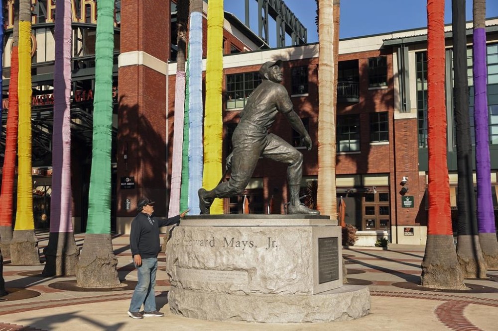 San Francisco Giants' fan Rich Mercurio touches former MLB player Willie Mays' statue outside Oracle Park after learning of his death, in San Francisco on Tuesday, June 18, 2024. Mays, the electrifying “Say Hey Kid” whose singular combination of talent, drive and exuberance made him one of baseball’s greatest and most beloved players, has died, according to a joint announcement by his family and the team Tuesday. (Scott Strazzante/San Francisco Chronicle via AP)