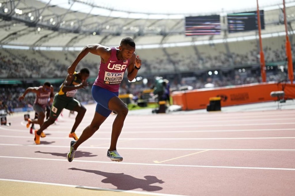 FILE -Erriyon Knighton, of the United States, competes in a Men's 200-meter heat during the World Athletics Championships in Budapest, Hungary, Wednesday, Aug. 23, 2023. Sprinter Erriyon Knighton tested positive for a banned substance that an arbitration panel determined came from contaminated meat, a decision that keeps the 200-meter specialist eligible to run at the upcoming Olympic trials, Wednesday, June 19, 2024. (AP Photo/Bernat Armangue, File)